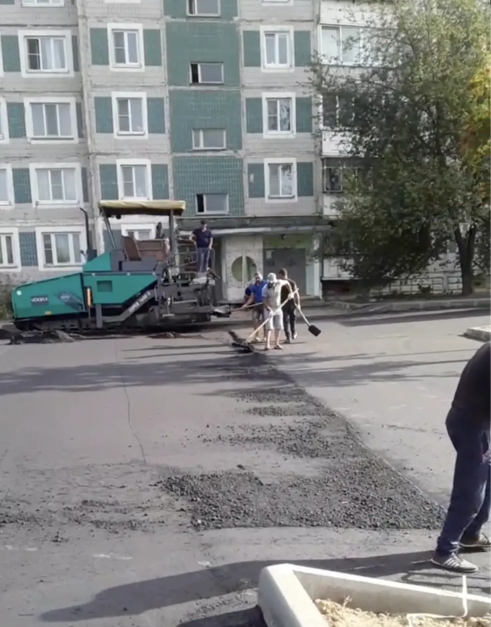 Бригада разравнивает асфальт